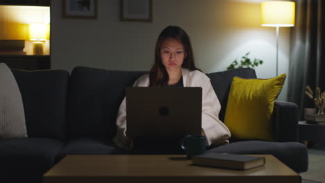 Woman-Spending-Evening-At-Home-Sitting-On-Sofa-With-Laptop-Computer-Looking-At-Social-Media-Streaming-Or-Scrolling-Online-7